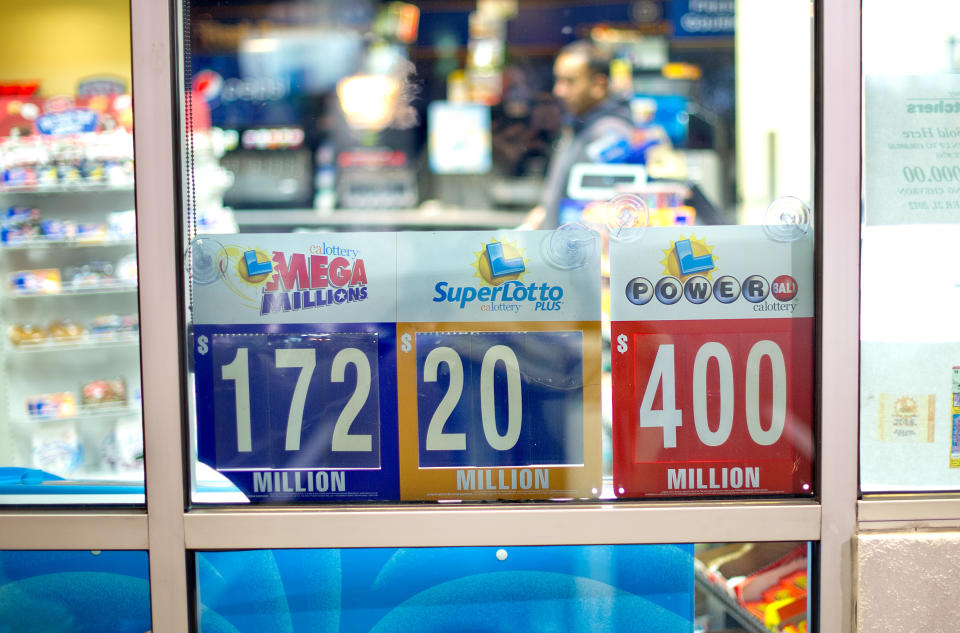 A night worker passes lottery signs at Dixon Landing Chevron in Milpitas, Calif., on Thursday, Feb. 20, 2014. According to California lottery officials, the store sold the lone winning ticket for a $425 million Powerball jackpot but there was no immediate word on who may have won one of the largest lottery jackpots in U.S. history. (AP Photo/Noah Berger)