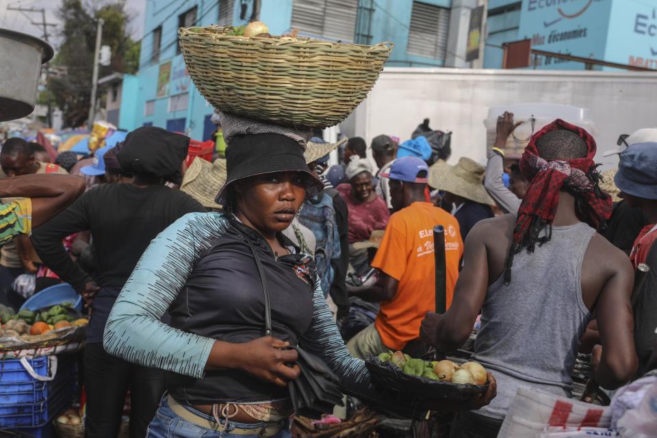 A street vendor balances a basket of vegetables on her head in the Petion-Ville neighborhood of Port-au-Prince, Haiti, Wednesday, April 10, 2024. (AP Photo/Odelyn Joseph)