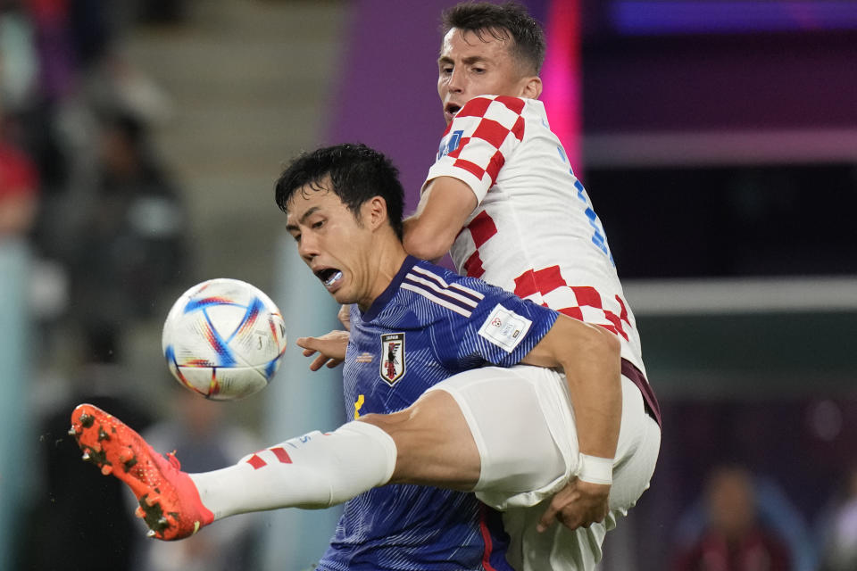 Japan's Wataru Endo, left, fights for the ball with Croatia's Ante Budimir during the World Cup round of 16 soccer match between Japan and Croatia at the Al Janoub Stadium in Al Wakrah, Qatar, Monday, Dec. 5, 2022. (AP Photo/Alessandra Tarantino)