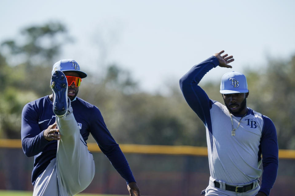 Tampa Bay Rays' Manuel Margot, left, and Randy Arozarena, right, stretch during spring training baseball practice on Thursday, Feb. 25, 2021, in Port Charlotte, Fla. (AP Photo/Brynn Anderson)