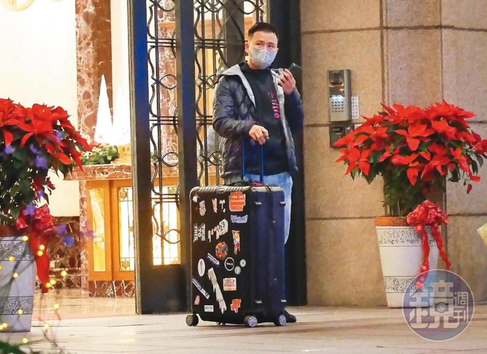 12月31日18：48，張劭緯拖著行李離開原來的家，在大樓門口等計程車。