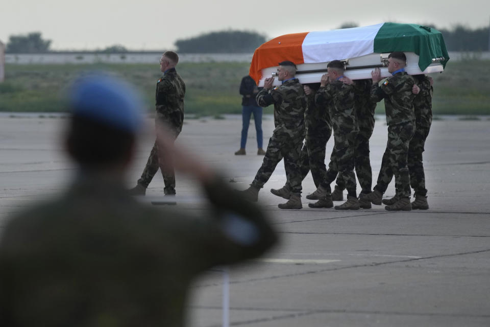 Irish U.N. peacekeepers, carry the coffin draped by their country flag of their comrade Pvt. Seán Rooney who was killed during a confrontation with residents near the southern town of Al-Aqbiya on Wednesday night, during his memorial procession at the Lebanese army airbase, at Beirut airport, Sunday, Dec. 18, 2022. (AP Photo/Hussein Malla)