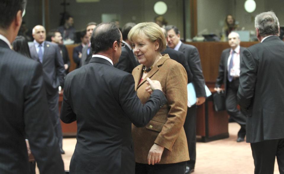 German Chancellor Angela Merkel, center right, speaks with French President Francois Hollande, center left, during a round table meeting at an EU summit in Brussels on Friday, Nov. 23, 2012. EU leaders begin what is expected to be a marathon summit on the budget for the years 2014-2020. The meeting could last through Saturday and break up with no result and lots of finger-pointing. (AP Photo/Yves Logghe)