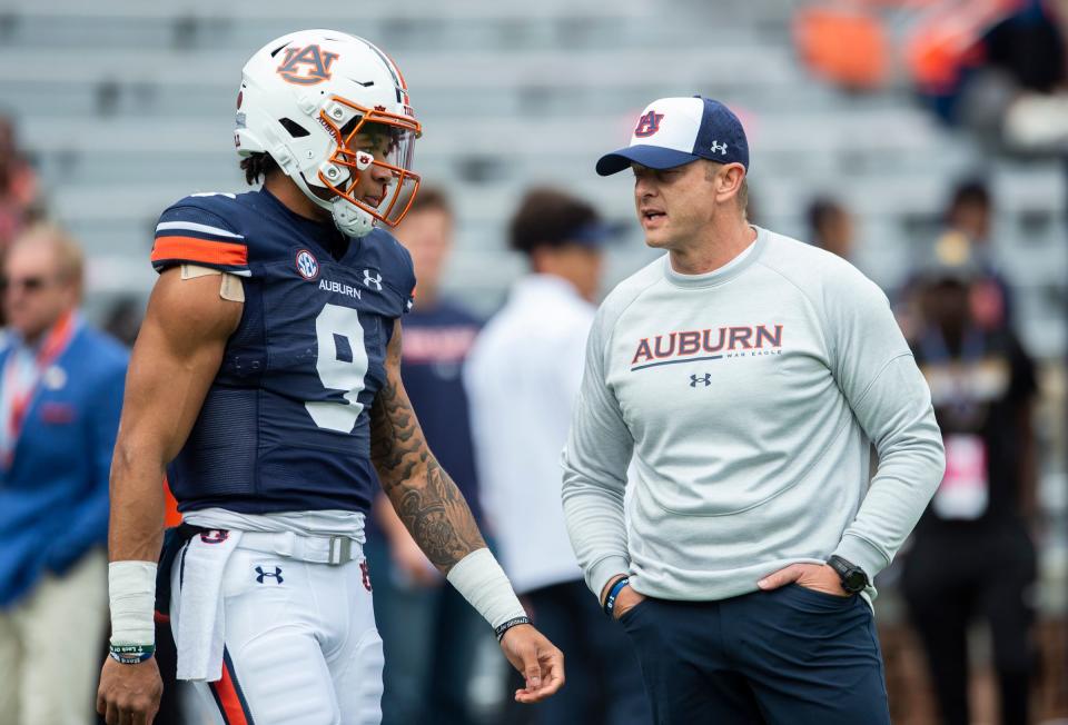 Auburn Tigers quarterback Robby Ashford (9) and Auburn Tigers head coach Bryan Harsin talk during warm ups before Auburn Tigers take on Arkansas Razorbacks at Jordan-Hare Stadium in Auburn, Ala., on Saturday, Oct. 29, 2022.