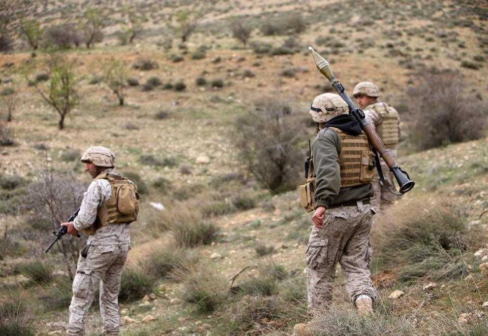 Lebanese army commandos patrol the area after they blew up a bomb-packed parked car in a field outside the village of Fakiha, near the Lebanese and Syria border, in northeast Lebanon, Monday, March 17, 2014. Lebanese commandos combed the tense border areas between Lebanon and Syria early Monday shortly after troops discovered and denoted an SUV rigged with explosives. The Lebanese army is searching for rebels crossing into the country after their last stronghold on the other side of the frontier fell into Syrian government hands on Sunday. (AP Photo/Hussein Malla)