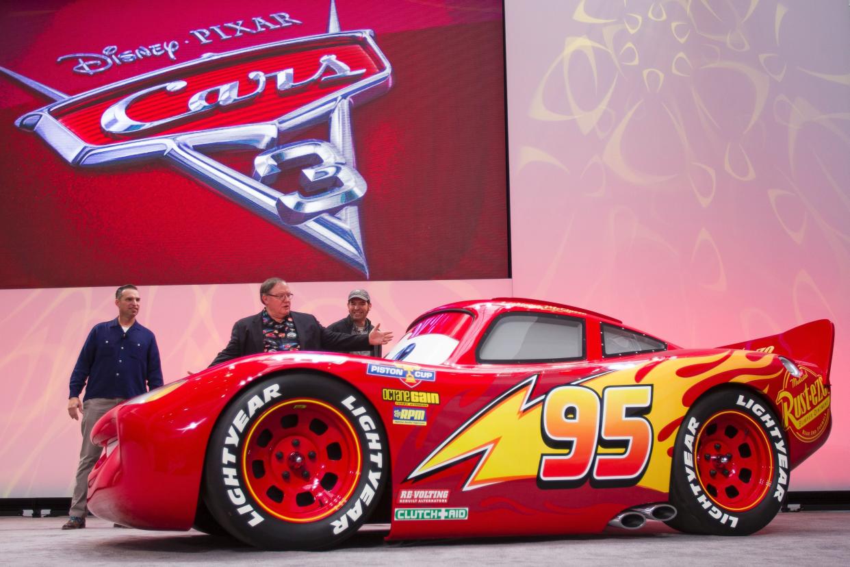 A life-size version of Lightning McQueen drives onstage to unveil his new paint job for the upcoming movie 'Cars 3'. (Photo: GEOFF ROBINS via Getty Images)