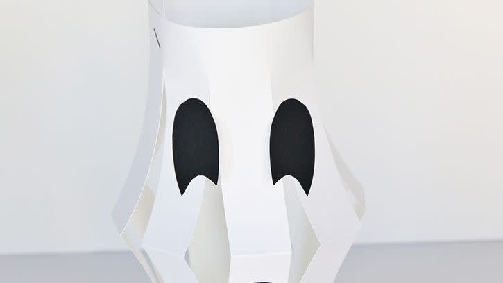 white paper lanterns with black paper eyes and mouth to resemble a ghost created for halloween activity
