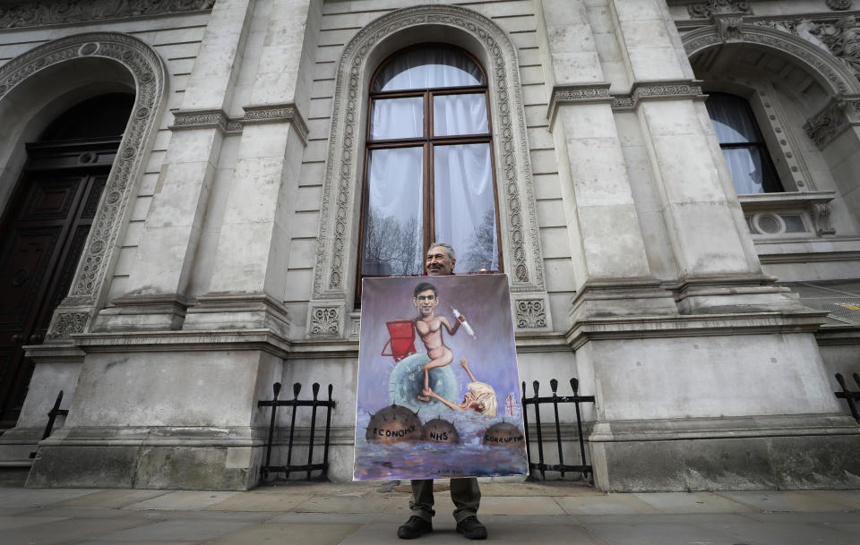 <p>Britain's Chancellor Rishi Sunak stands with his red briefcase in front of 11 Downing Street in London, Wednesday, March 3, 2021. Sunak is expected to announce billions of pounds in tax cuts and spending increases to help workers and businesses hit by the coronavirus pandemic when he delivers his budget to Parliament on Wednesday. (AP Photo/Kirsty Wigglesworth)</p>
