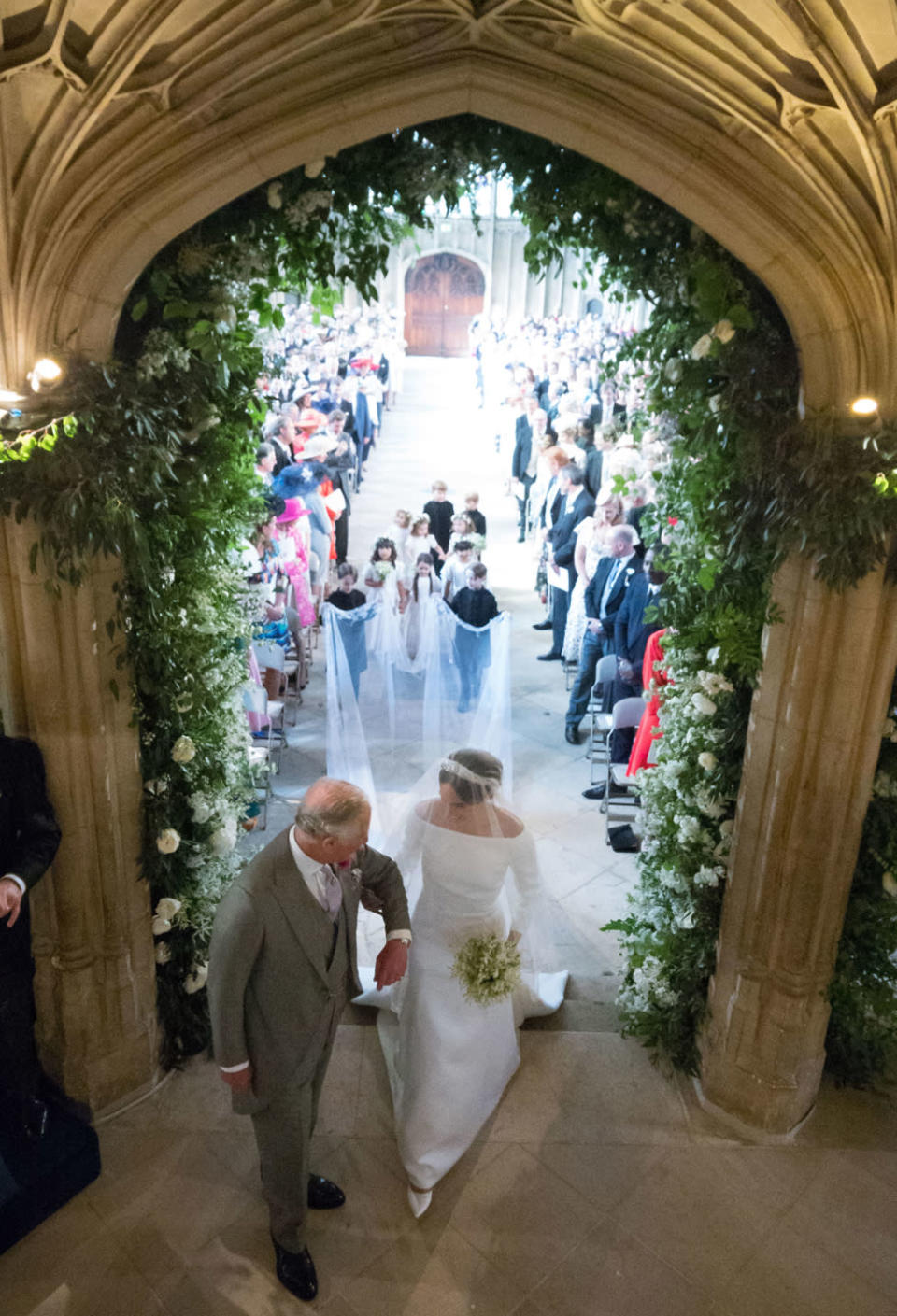 Meghan Markle, acompañada por el rey Carlos III de Reino, camina por el pasillo de la Capilla de San Jorge, en el castillo de Windsor, durante la ceremonia de su boda con el príncipe Harry el 19 de mayo de 2018.