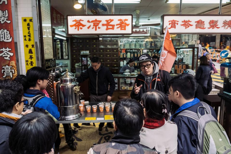 A tour guide, center right, with a group of tourists outside a traditional Chinese medicine pharmacy during a guided walking tour hosted by Klook in Hong Kong in 2018.