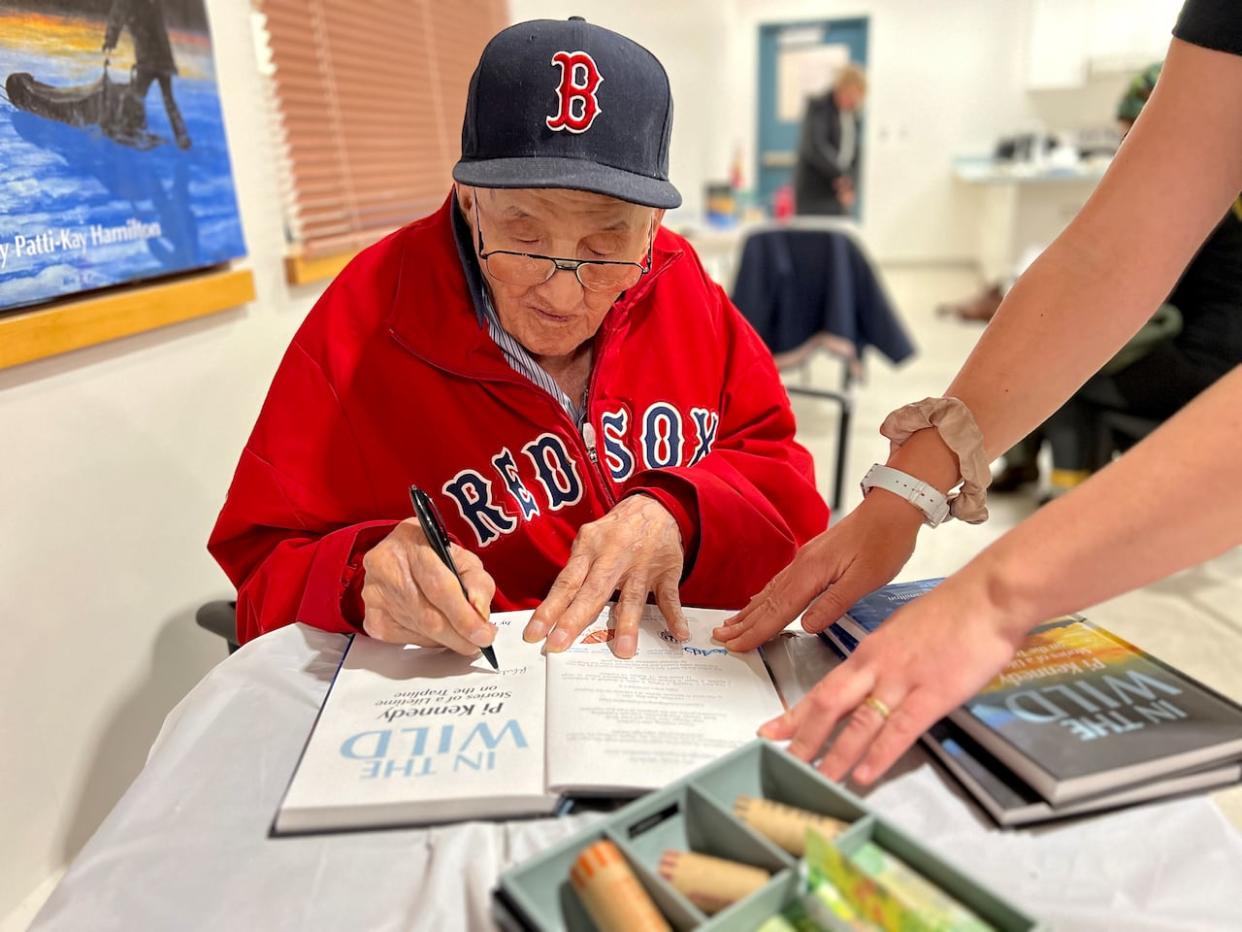 Pi Kennedy signing books at the Fort Smith book launch. (Carla Ulrich/CBC - image credit)