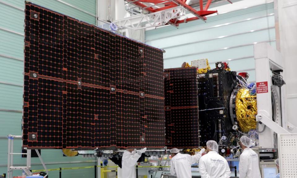 Technicians look at a solar panel on the Inmarsat S-Band/Hellas-Sat 3 satellite in the clean room facilities of the Thales Alenia Space plant in Cannes, France