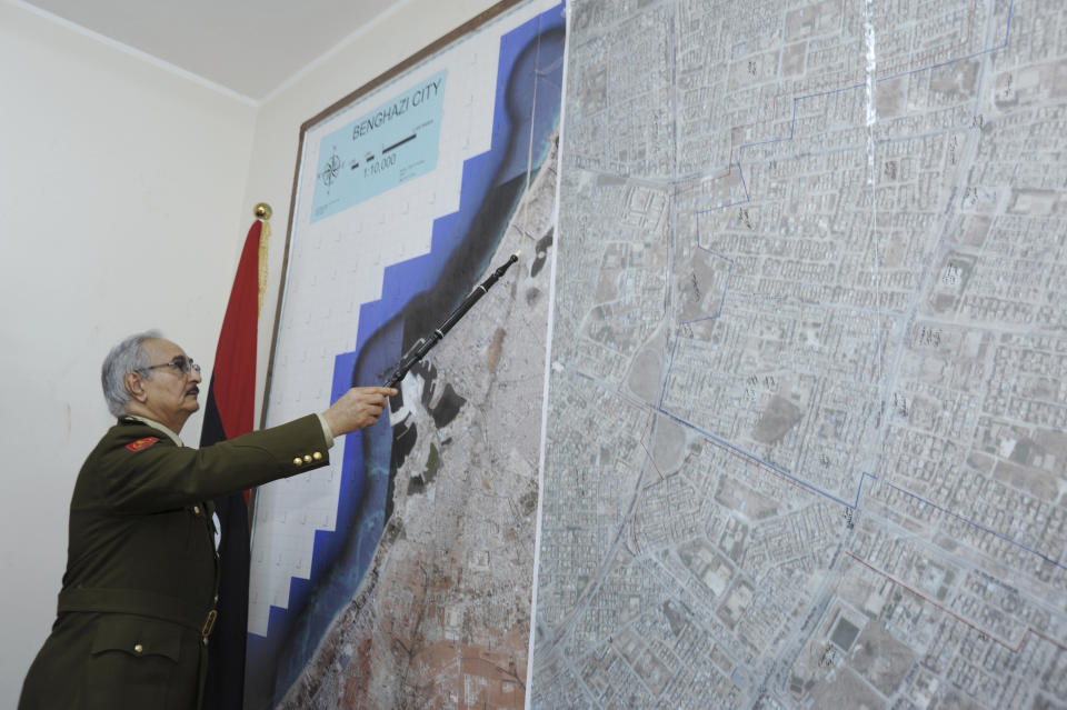 FILE - In this In this Wednesday, March 18, 2015 photo, Gen. Khalifa Hifter, Libya's top army chief, points at a map in his office during an interview with the Associated Press in al-Marj, Libya. Libya has been plunged into chaos again, with forces loyal to a polarizing military commander marching on the capital and trading fire with militias aligned with a weak U.N.-backed government. (AP Photo/ Mohammed El-Sheikhy, File)