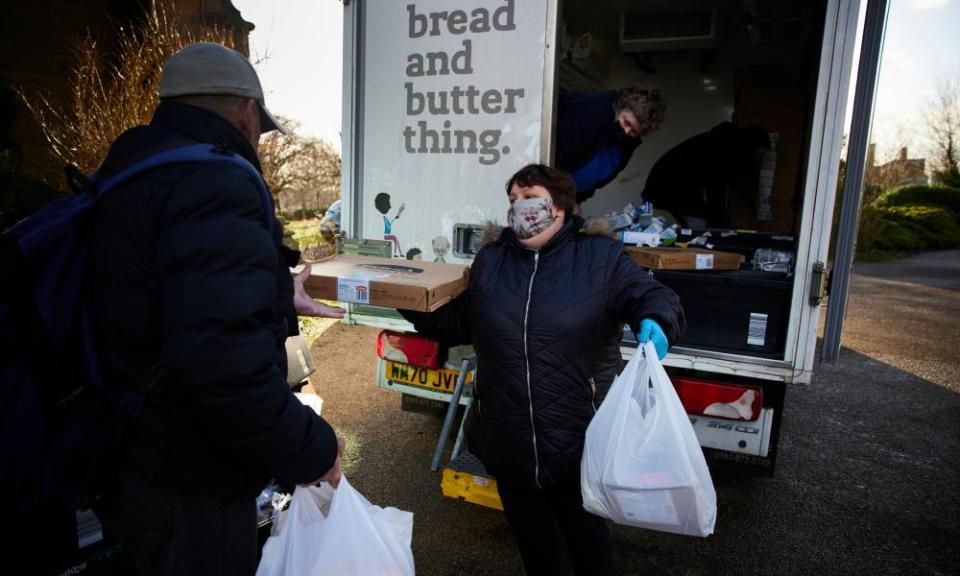 A volunteer for the Bread and Butter Thing hands out the weekly food parcels outside St Peter’s Church in Ashton-under-Lyne, Greater Manchester