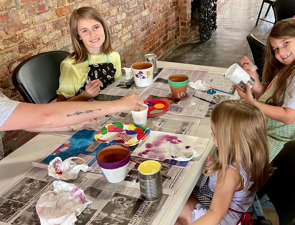 Attendees of "Live a Little" summer reading program paint terracotta pots and tin cans for a gardening lesson on June 6, 2023, at the Collinsville Public Library in Collinsville, Alabama.