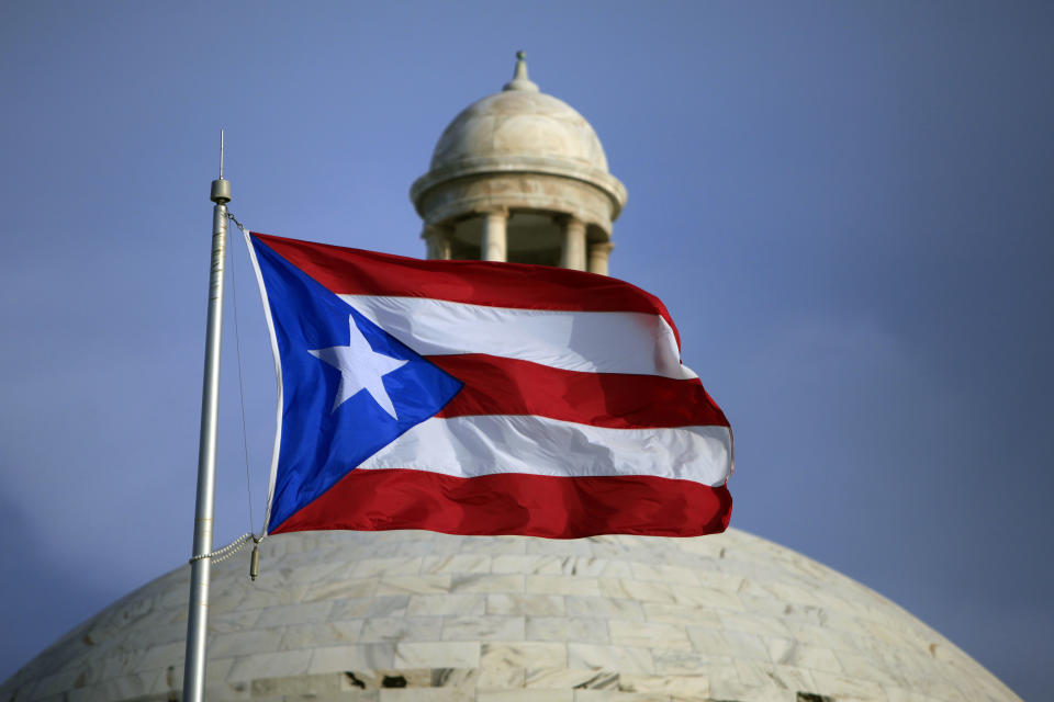 ARCHIVO - La bandera de Puerto Rico ondea frente al Capitolio, en San Juan, Puerto Rico, el 29 de julio de 2015. (AP Foto/Ricardo Arduengo, archivo)