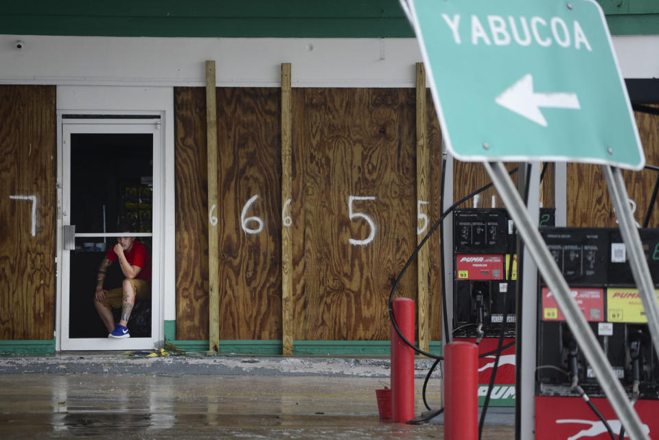 Un hombre mira por la ventana de una gasolinera protegida con tablas de madera tras el paso del huracán María por la región oriental de la isla, en Humacao, Puerto Rico, el 20 de septiembre de 2017. El huracán más potente en la isla en más de 80 años destrozó cientos de casas, cortó la electricidad en todo el país y anegó algunas calles. (AP Foto/Carlos Giusti)