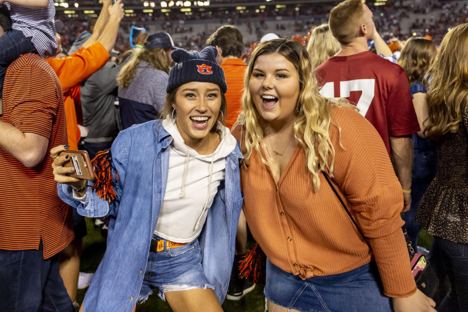 Auburn fans celebrate as other fans rush the field following an upset of Alabama in an NCAA college football game, Saturday, Nov. 30, 2019, in Auburn, Ala. (AP Photo/Vasha Hunt)