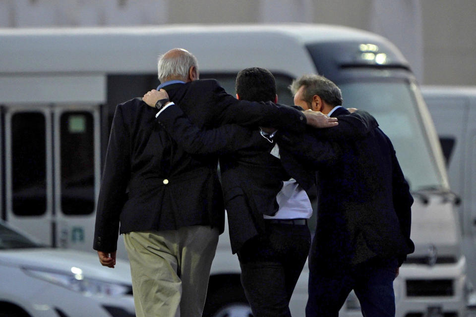 Morad Tahbaz, Siamak Namazi, and Emad Sharghi walk shoulder to shoulder from the flight that brought them out of Tehran, Iran, to Doha