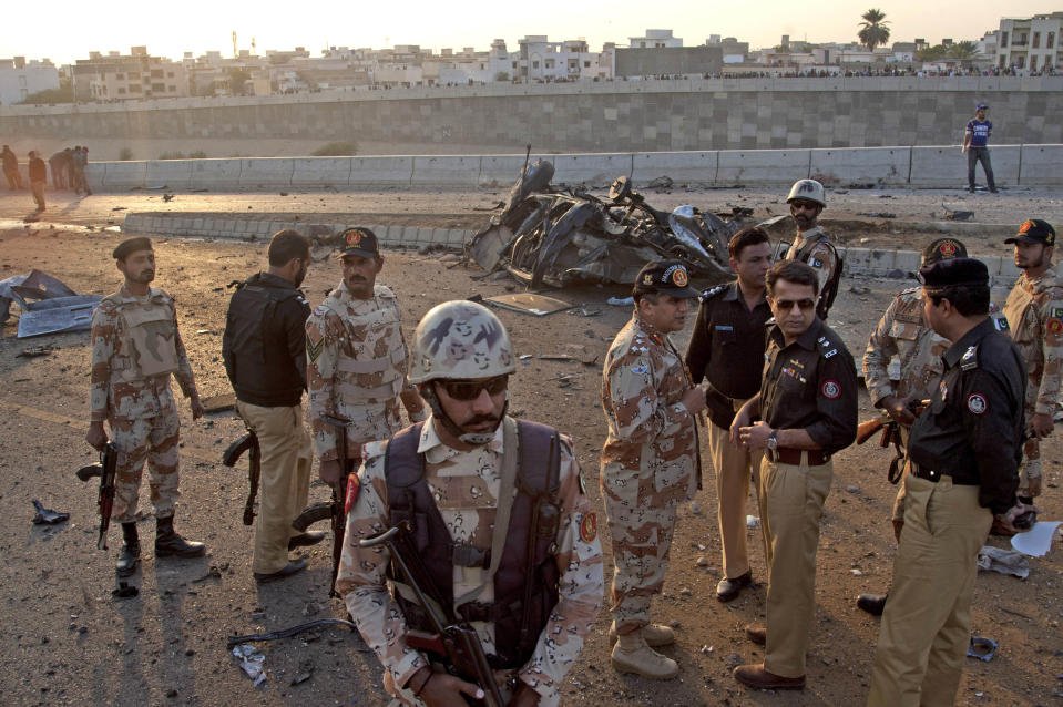 Members of Pakistani security agencies inspect the site of a bombing in Karachi, Pakistan, Thursday, Jan. 9, 2014. Police said a car bomb has killed a senior police investigator known for arresting dozens of Pakistani Taliban, as well as two other officers. (AP Photo/Shakil Adil)