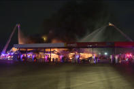 In this image taken from a video provided by KSAT-TV, firefighters battle flames from a truck stop fire in San Antonio, Texas, early Thursday morning, Dec. 1, 2022. (KSAT-TV via AP)