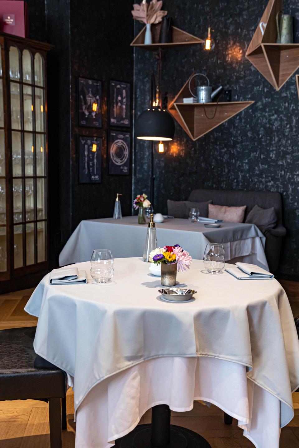 a corner of the dining room at L'Appart with a table cloth topped table in the foreground