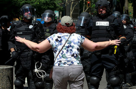 A counter-protester argues with police during a rally by the Patriot Prayer group in Portland, Oregon, U.S. August 4, 2018. REUTERS/Bob Strong