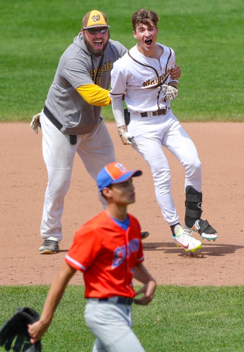 Waynedale's first base coach and Connor Gatti celebrate Gatti's game winning hit in the 8th inning of their 2-1 win over Milan Edison in a Division III  State Championship game on Saturday, June 11, 2022 in Akron, Ohio, at Canal Park.