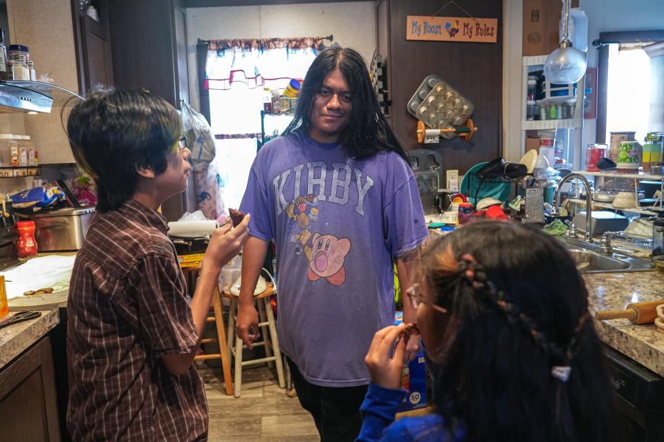 Ruben Patina-Trujillo, center, waits for feedback on some baked goods from his siblings Margarito Patina-Trujillo, left, and Eliza Patina-Trujillo, right, in their home in Del Valle. Ruben would like to learn to drive so he can help his family more. His mother needs new tires on her car.