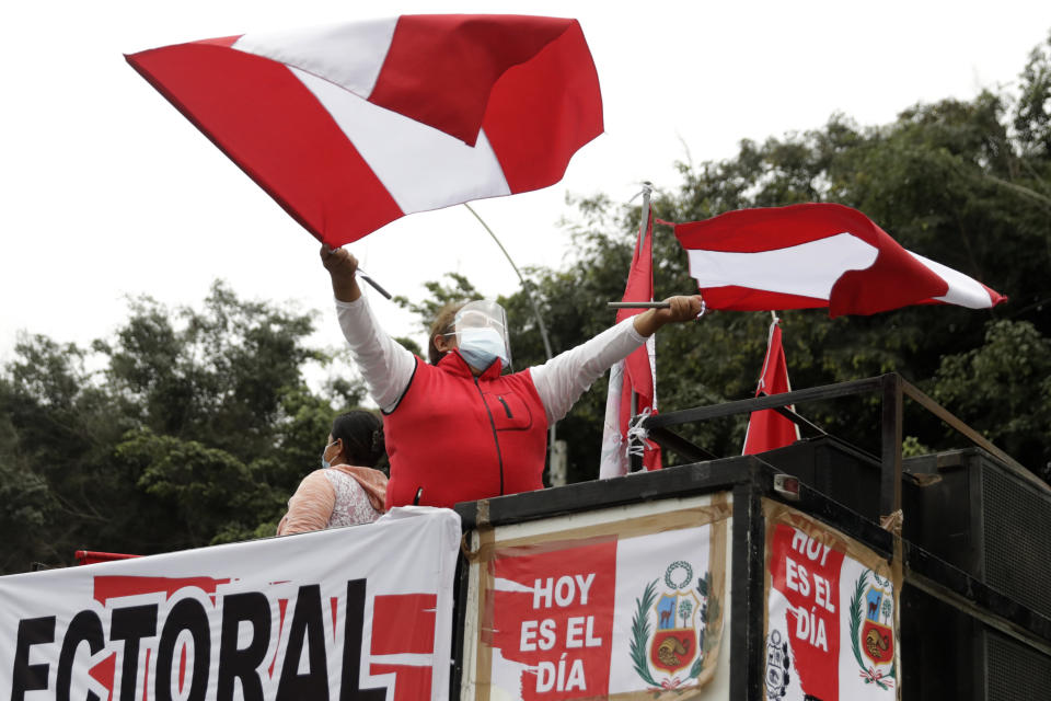 A supporter of presidential candidate Keiko Fujimori waves banners during a protest against alleged election fraud, in Lima, Peru, Saturday, June 12, 2021. Supporters are hoping to reverse the results of the June 6th presidential runoff election that seem to have given the win to opponent Pedro Castillo amid unproven claims of possible vote tampering. (AP Photo/Guadalupe Pardo)