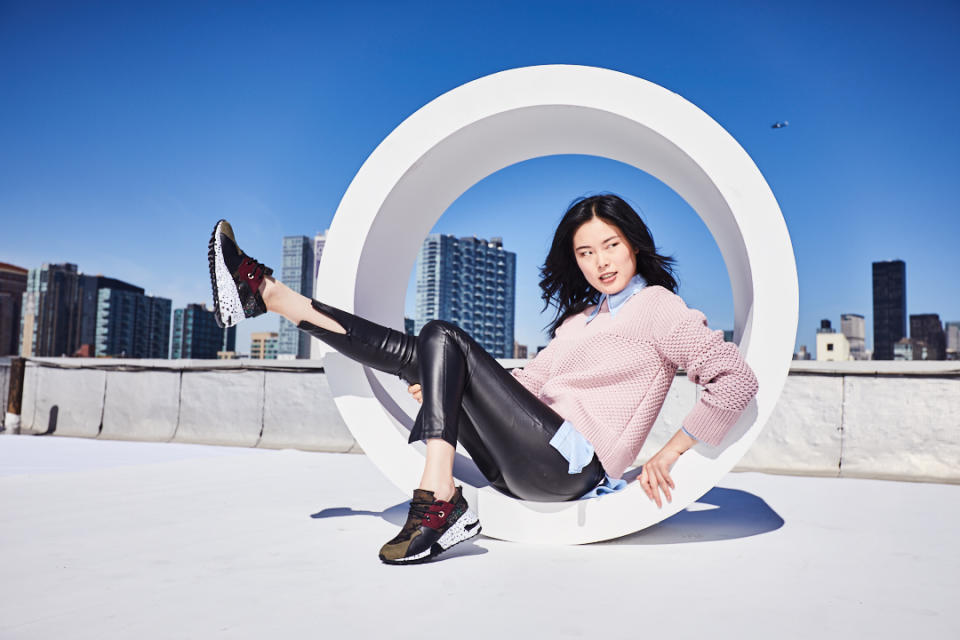 Woman sitting in tube with sneakered foot raised