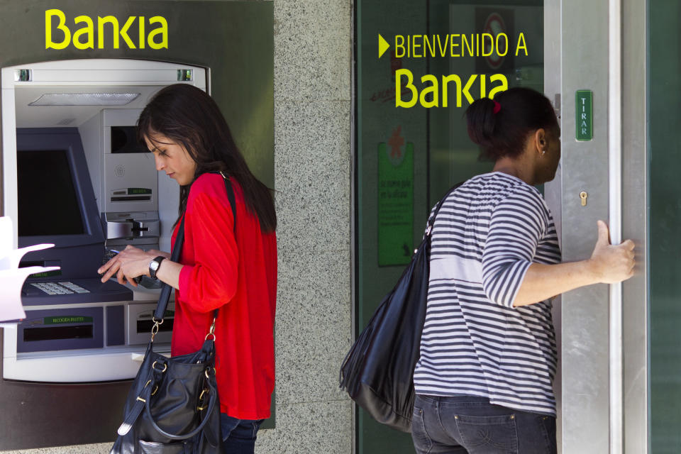 Una mujer utiliza un cajero automático en una sucursal del banco Bankia en Madrid. (AP foto/Daniel Ochoa de Olza)