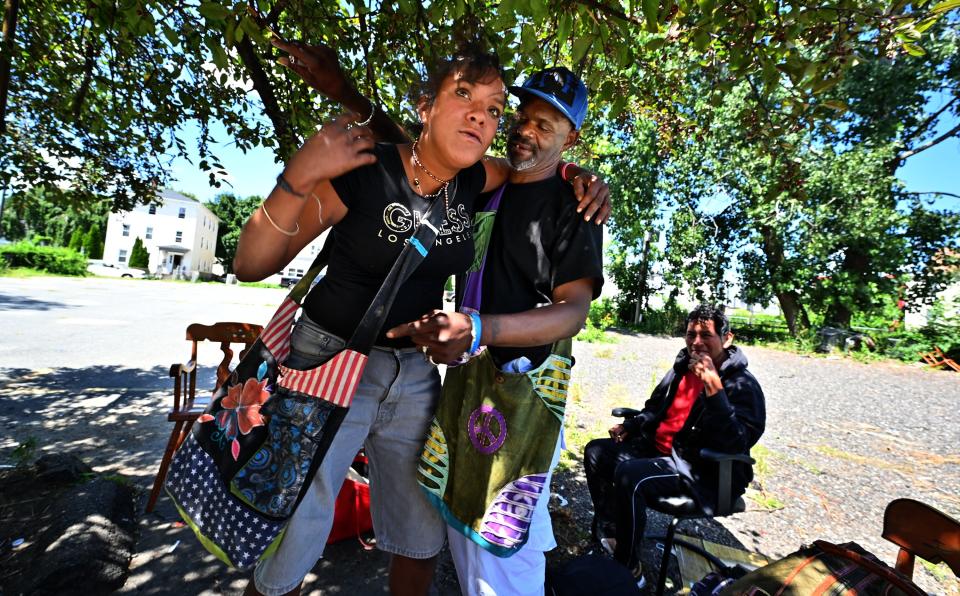 WORCESTER - Calvin Gray and Yanesis Smith embrace in the shade of a crabapple tree in an empty lot on Harding Street. Homeless, they have spent much of their time under the tree hiding out from the recent heat wave.
