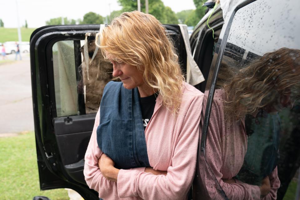 Mary Schierkolk-Ames looks down while speaking Friday from the back seat of her Jeep, in which she lives in North Topeka.