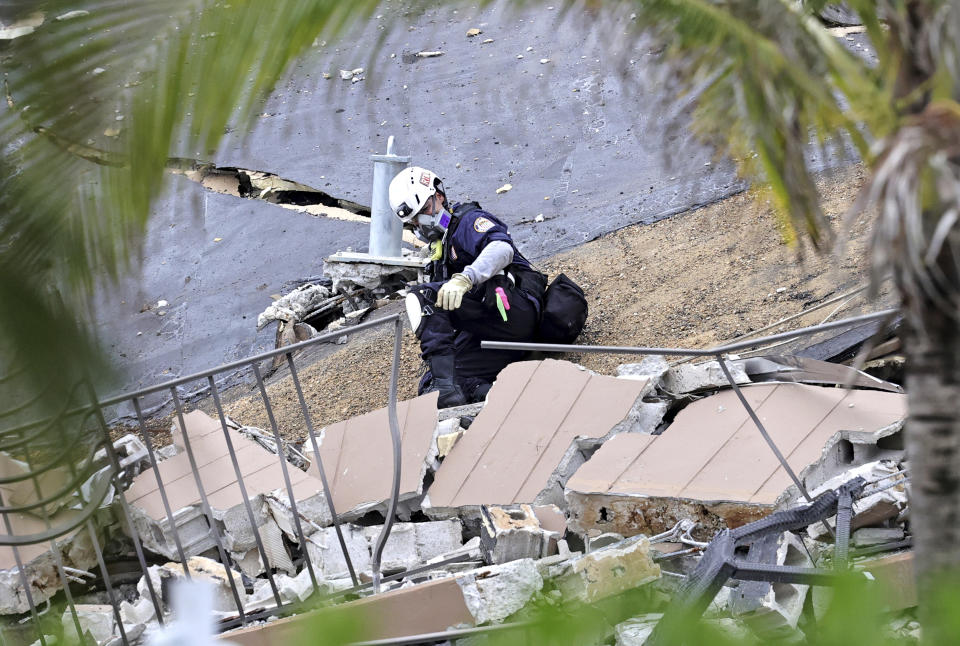 Search and rescue personnel search for survivors through the rubble at the Champlain Towers South Condo in Surfside, Fla., Friday, June 25, 2021. The apartment building partially collapsed on Thursday, June 24. (David Santiago/Miami Herald via AP)