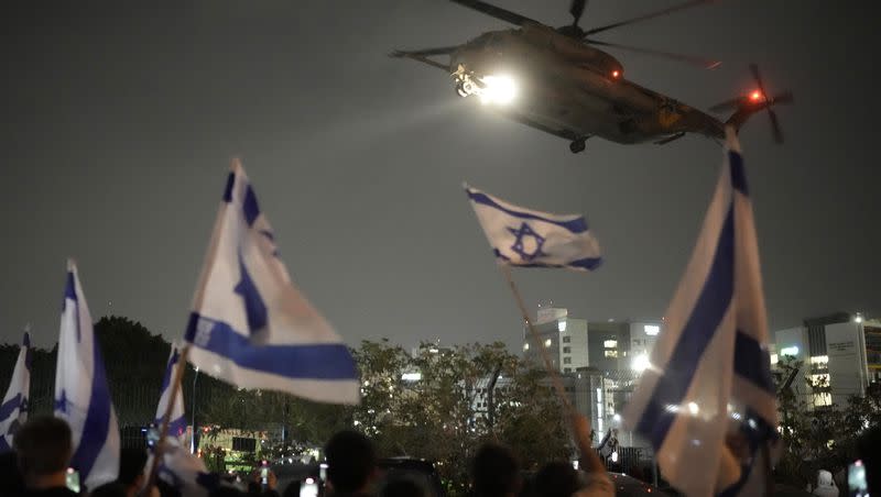 People waves Israeli flags as a helicopter carrying hostages released from Gaza by Hamas arrives at the helipad of the Schneider Children’s Medical Center in Petah Tikva, Israel, on Nov. 26, 2023. The cease-fire between Israel and Hamas was back on track Sunday as the militants freed 17 more hostages, including 14 Israelis and the first American, in exchange for 39 Palestinian prisoners in a third set of releases under a four-day truce.