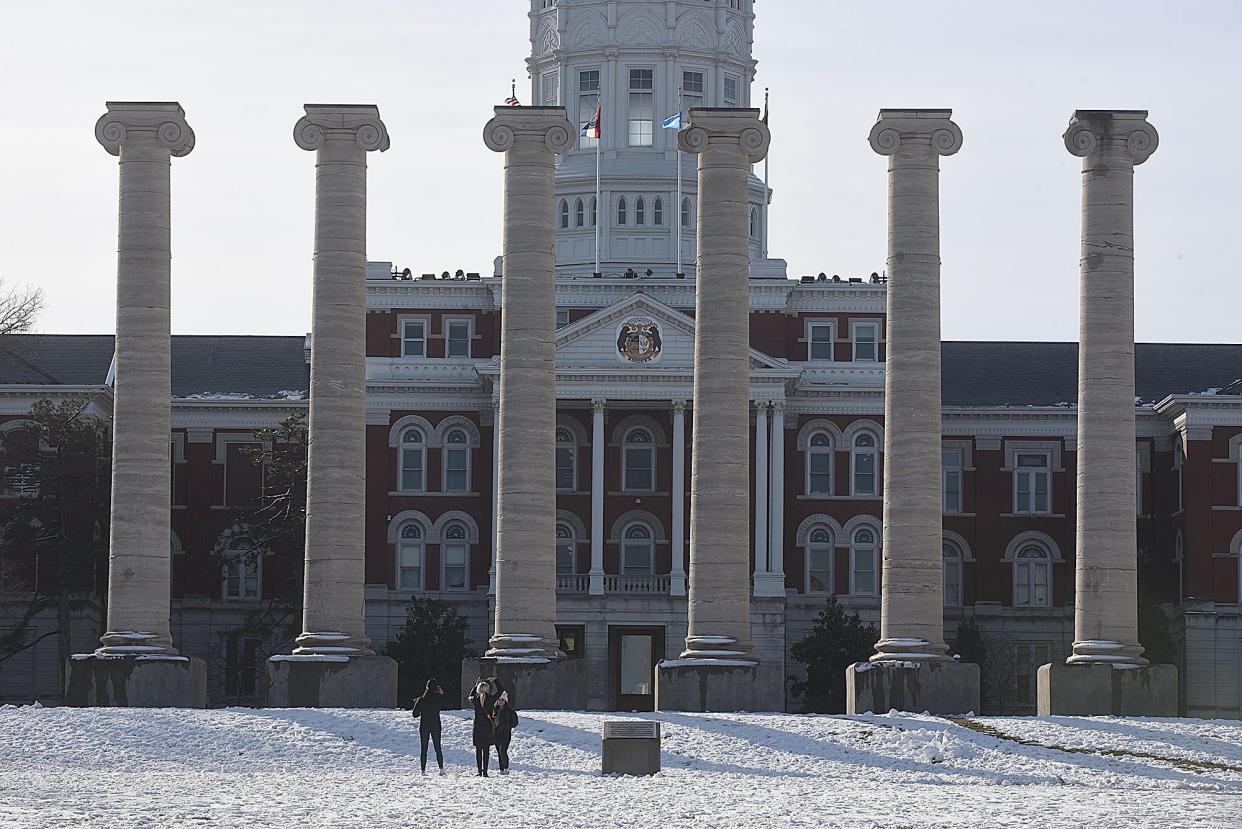 A group stops to take photos in front of the historic Columns in front of Jesse Hall in a Tribune file photo during the first day of spring semester 2022 classes.