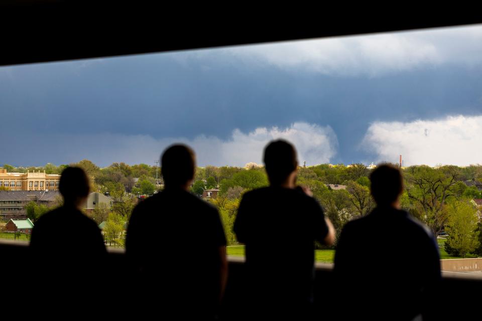 From left; Ally Mercer, Gabe Sedlacek Kaleb Andersen and Austin Young watch a tornado from a seventh floor parking garage on Friday, April 26, 2024, in Lincoln, Neb. (Kenneth Ferriera/Lincoln Journal Star via AP)