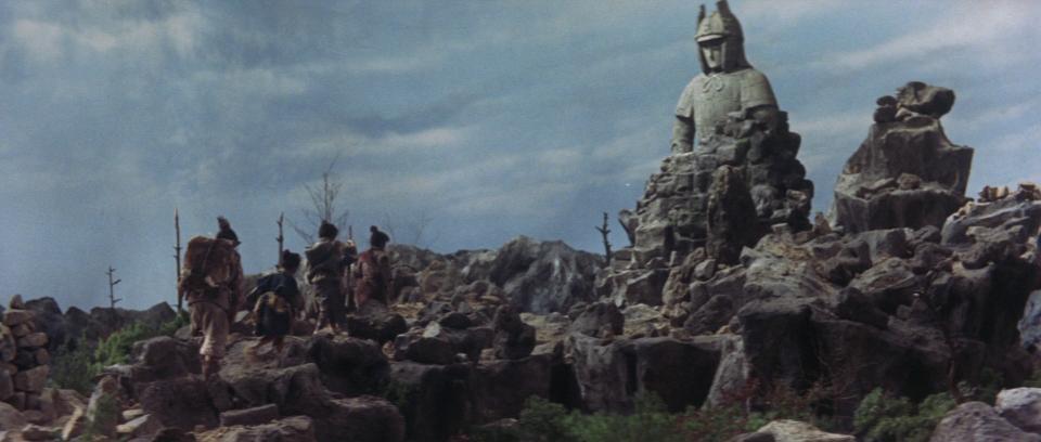 young children in feudal Japan trudge across rocky terrain to reach the dormant statue of Daimajin.