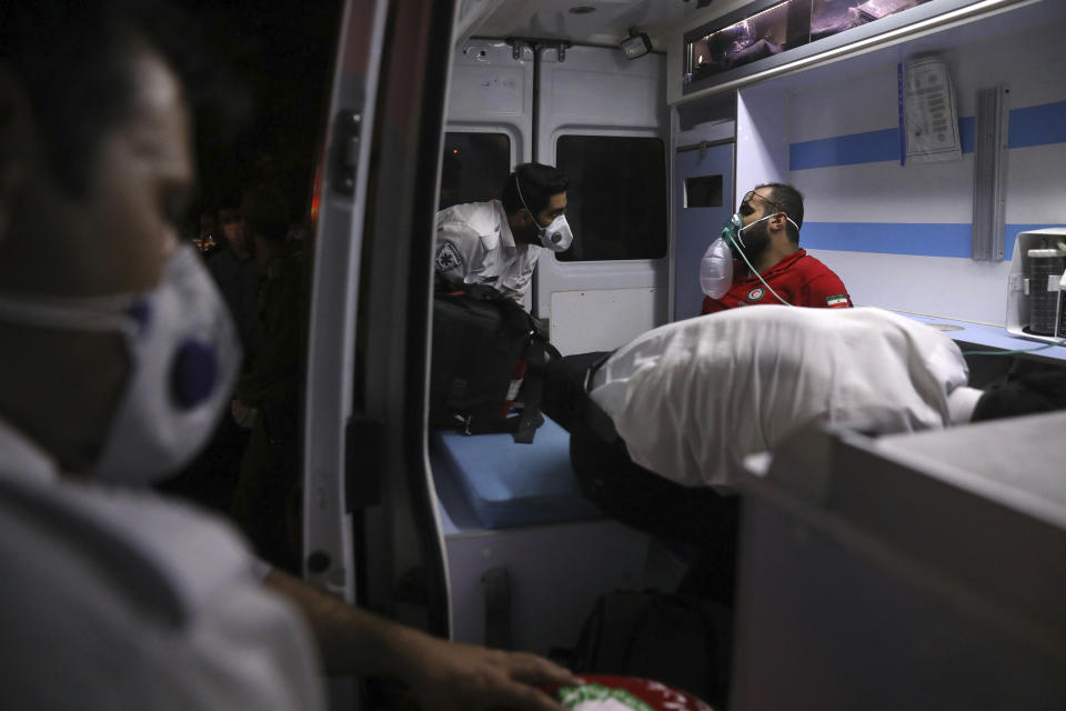 A rescue worker receives oxygen in an ambulance after he was overcome by smoke from the explosion of Sina Athar Clinic in Tehran, Iran, early Wednesday, July 1, 2020. Iranian state TV says an explosion from a gas leak in a medical clinic in northern Tehran has killed multiple people. (AP Photo/Vahid Salemi)