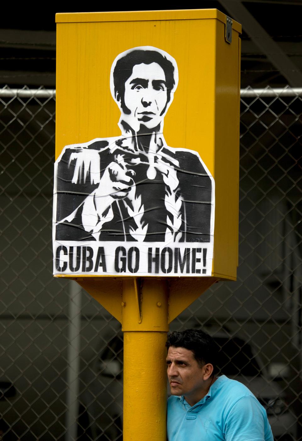 A demonstrators sits next to a banner with the image of Venezuelan hero Simon Bolivar during an anti-government protest in Caracas, Venezuela, Saturday, April 26, 2014. Student organizers at the last minute decided against marching downtown to avoid a confrontation with security forces in the government-controlled district. Instead they concentrated in the wealthier, eastern neighborhoods that have been the hotbed of unrest since February. (AP Photo/Fernando Llano)