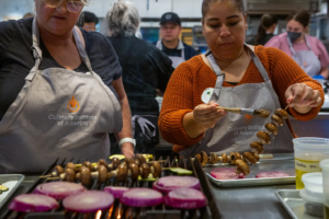 As part of Farm to School, an initiative to provide healthier lunches in California schools, School food service workers at San Luis Coastal Unified School District, Teresa Vigil, left, and Maria Martínez, right, train at the Culinary Institute of America in Napa on Aug. 3, 2023. (Semantha Norris/CalMatters)