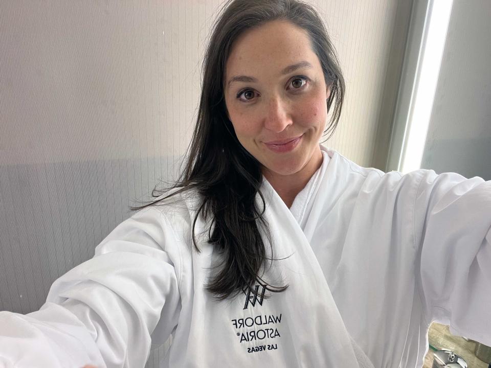 A woman taking a selfie wearing a hotel robe.