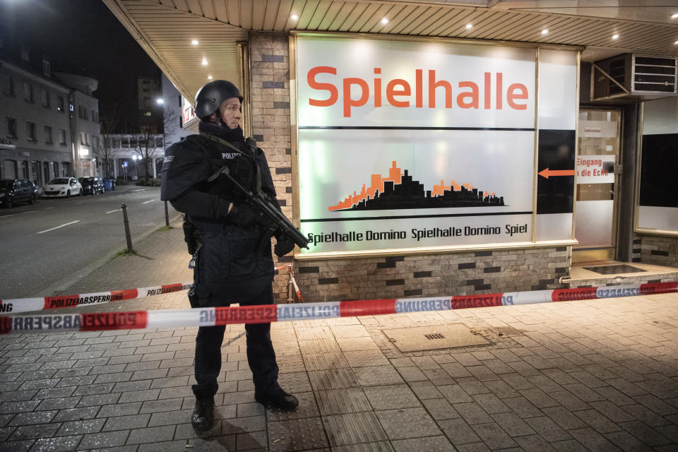 A police officer stands guard in front of a gambling hall near the scene after a shooting in central Hanau, Germany Thursday, Feb. 20, 2020. Eight people were killed in shootings in the German city of Hanau on Wednesday evening, authorities said. (Andreas Arnold/dpa via AP)