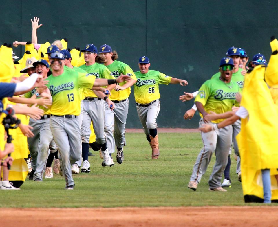 Savannah Bananas coach Tyler Gillum (66 in cowboy boots) joins the Coastal Plains League team as it runs through a phalanx of banana-costumed fans before the start of their Banana Fest game May 24 at Grayson Stadium.