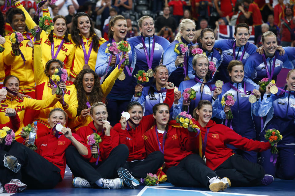 Medallists from Norway (blue), Montenegro (red) and Spain (yellow) pose during the victory ceremony for the women's handball final during the London 2012 Olympic Games at the Basketball Arena August 11, 2012. Norway won the gold, Montenegro silver and Spain the bronze. REUTERS/Marko Djurica (BRITAIN - Tags: SPORT HANDBALL OLYMPICS) 