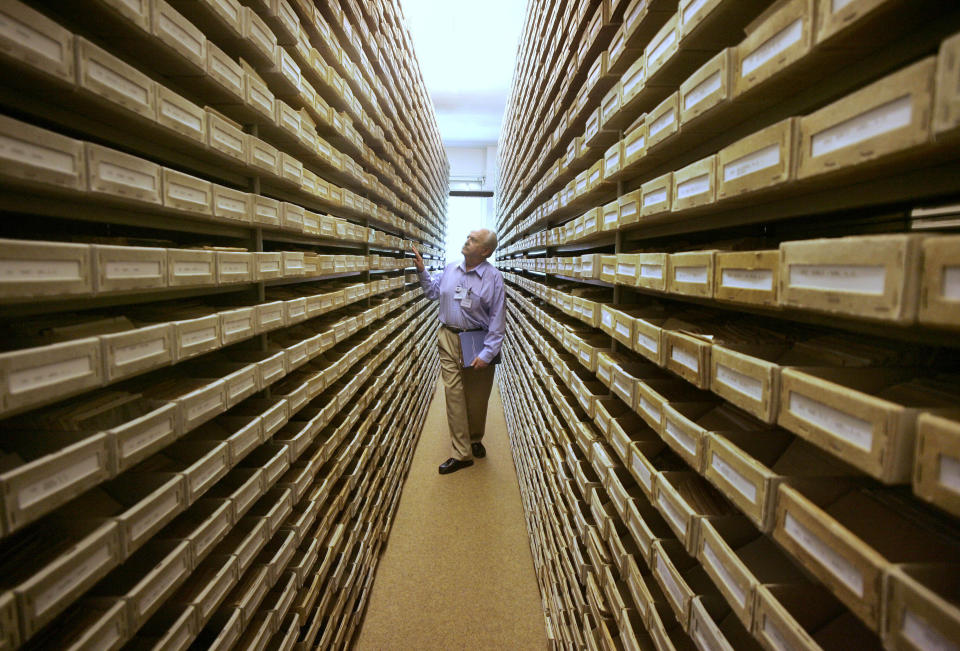 In this May 8, 2008 file picture Gary Mokotoff, a Jewish genealogist from New Jersey, takes a look at name registers at the International Tracing Service in Bad Arolsen, central Germany. (AP Photo/Michael Probst, file)