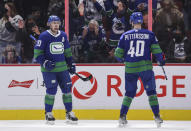 Vancouver Canucks' Tanner Pearson, left, and Elias Pettersson, of Sweden, celebrate Pearson's goal against the St. Louis Blues during first-period NHL hockey game action in Vancouver, British Columbia, Sunday, Jan. 23, 2022. (Darryl Dyck/The Canadian Press via AP)