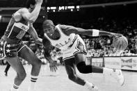 FILE - Chicago Bulls' Michael Jordan drives past Washington Bullets' Dudley Bradley during NBA action in Chicago, on Oct. 26, 1984. (AP Photo/Fred Jewell, File)