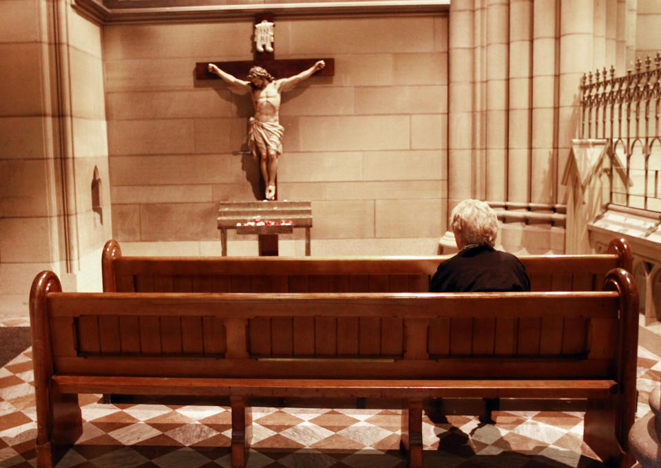 A Catholic devotee prays at the St Mary's Cathedral in central Sydney February 12, 2013. Pope Benedict left the Catholic world in shock after becoming the first pontiff since the Middle Ages to resign his office, saying that failing strength had left him unable to lead the church through a period of relentless change and turmoil. The 85-year-old pontiff announced his abdication as leader of the world's 1.2 billion Catholics in a speech delivered in Latin, the universal language of the church, to cardinals meeting in the Vatican's Apostolic Palace. REUTERS/Daniel Munoz (AUSTRALIA - Tags: RELIGION) - RTR3DNYD